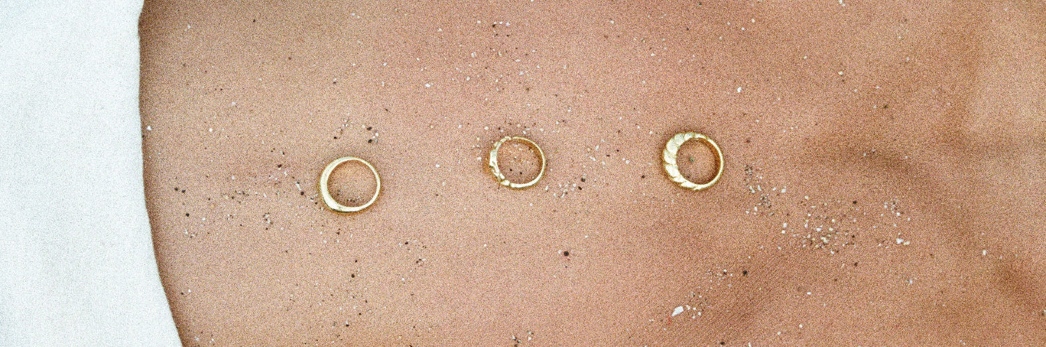 Three gold belly buttons on a person's stomach